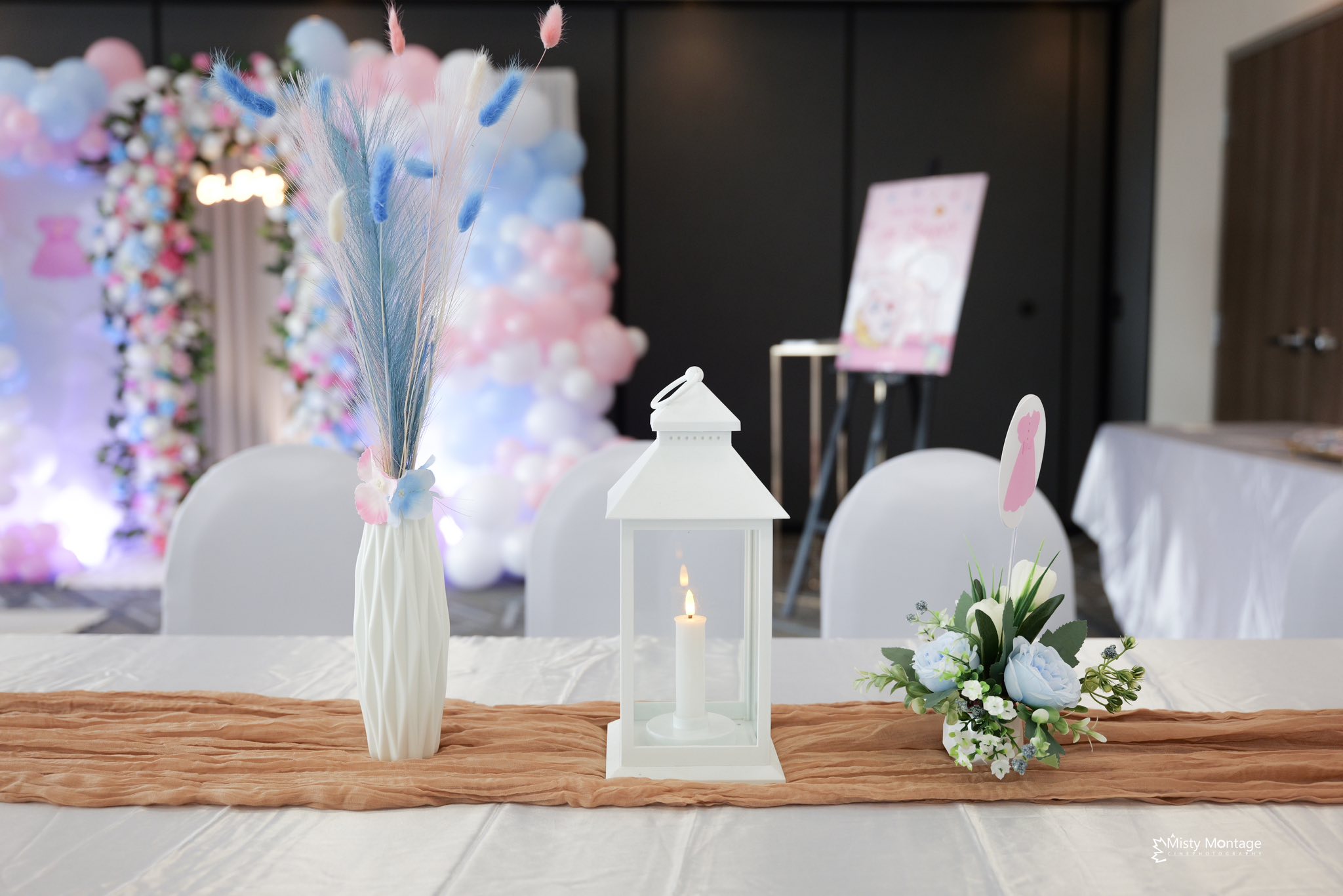 Gender reveal — pink and blue balloon wall with flower arch