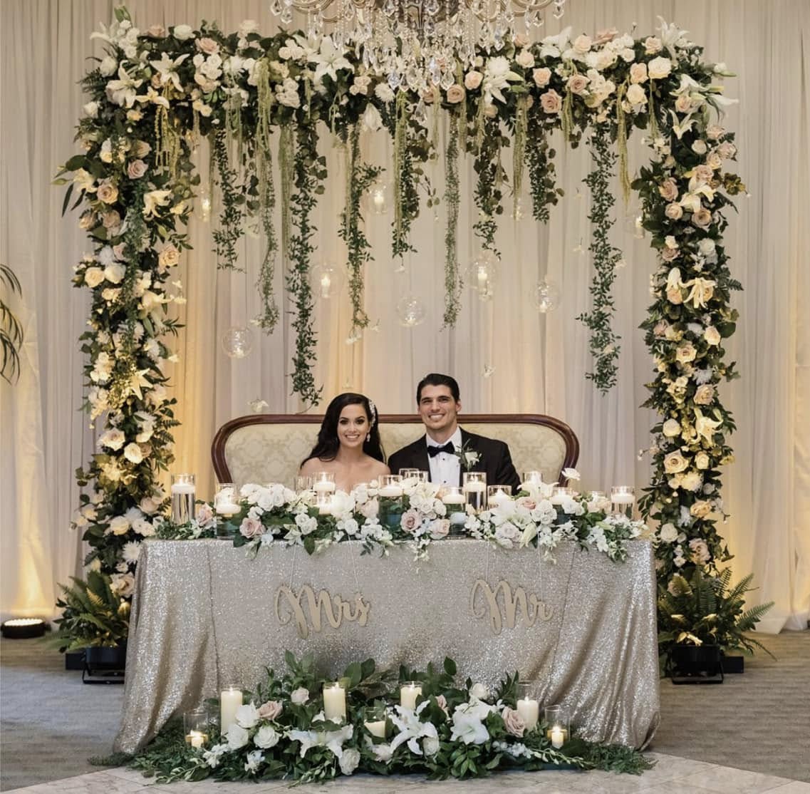 Wedding reception — sweetheart table with floral arch